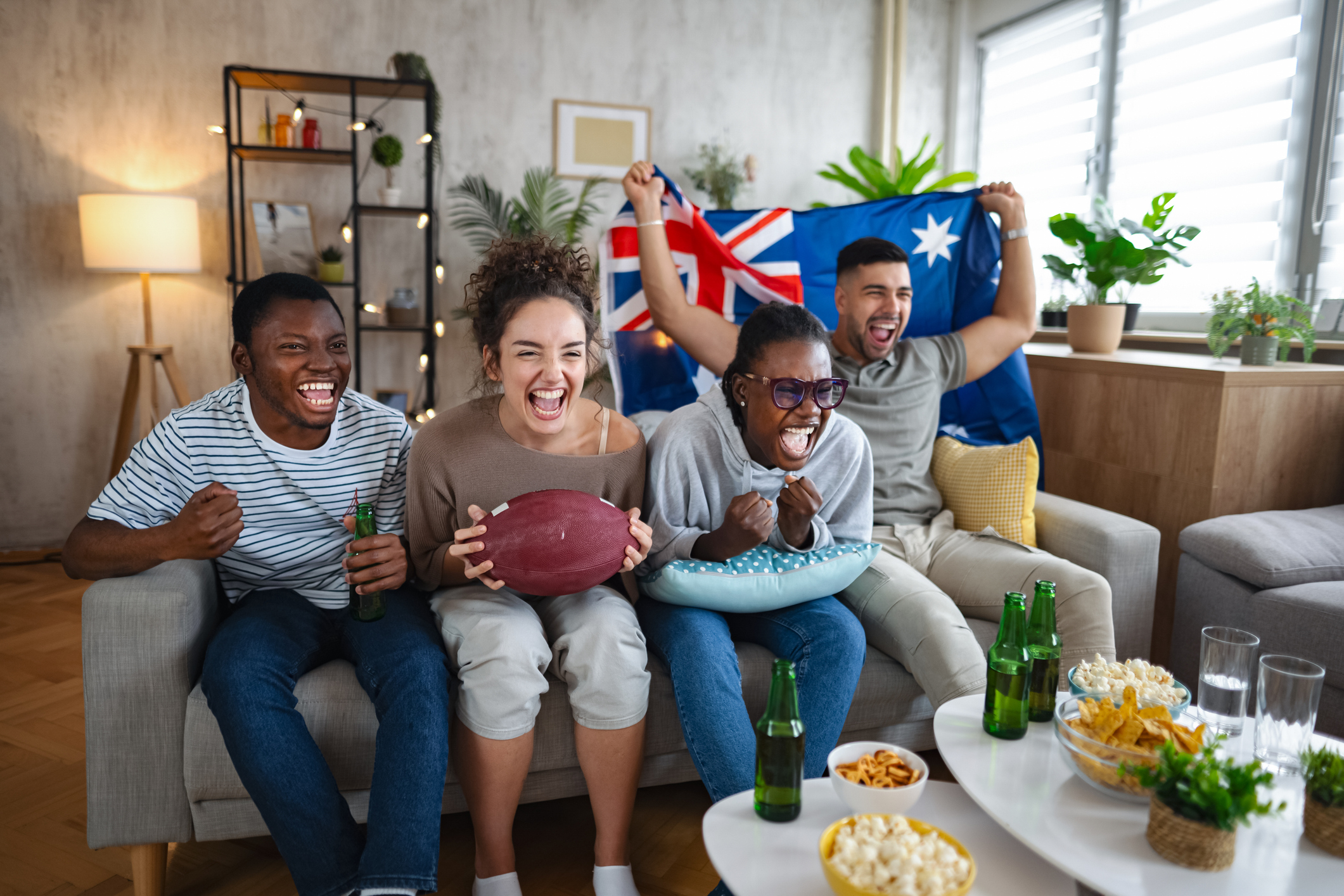 Excited friends watching rugby match at home and cheering for Australia